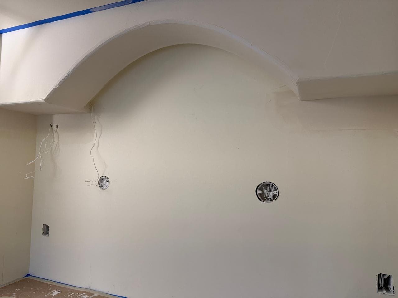 Curved arch taking shape above the wall, mud still drying