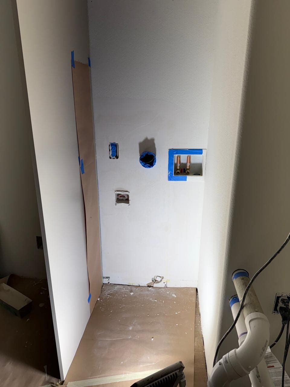 Laundry wall with cutouts around the pipes and outlets