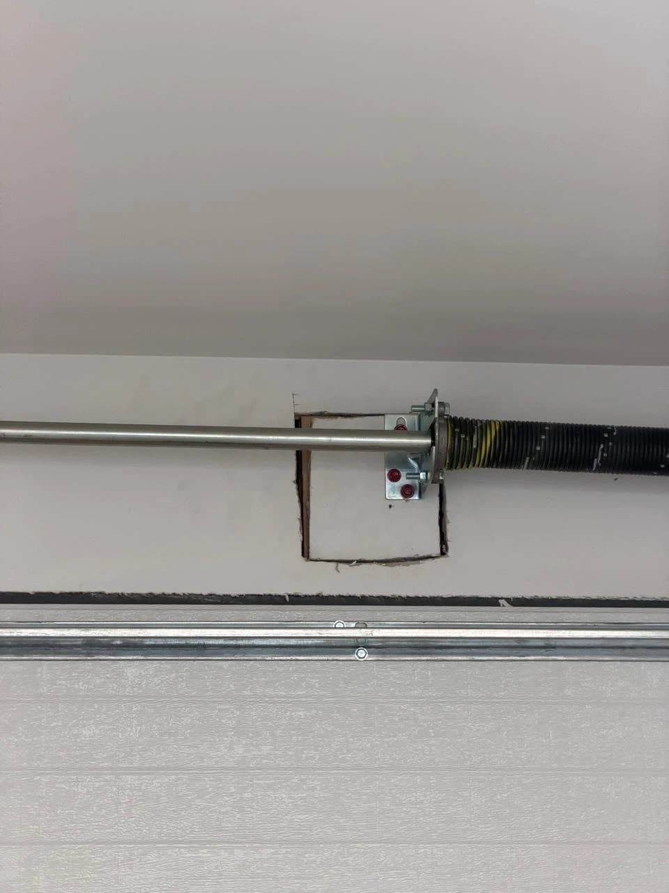 Open cutout around the garage door spring bracket